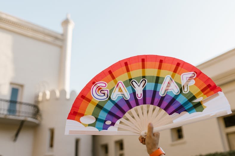 un éventail aux couleurs lgbt brandit pour la communauté gay