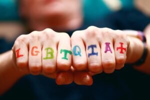 des poings liés avec les lettres lgbtqia+, ce paragraphe donne des conseils aux voyageurs lgbt
