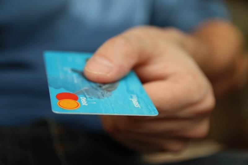 une main tient une carte bancaire pour voyager au Cap Vert.