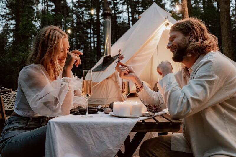 un couple qui trinque lors d'un glamping en amoureux