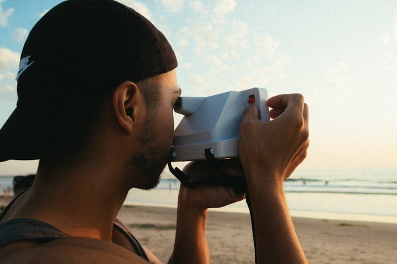 Un jeune homme prend des photos de la mer à Sal, c'est un touriste qui explore les environs.