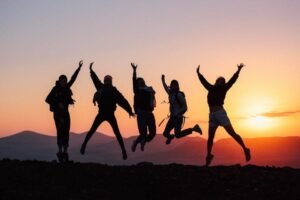 Un groupe de personne en excursion, saute de joie, la nuit au coucher du soleil à Sal.